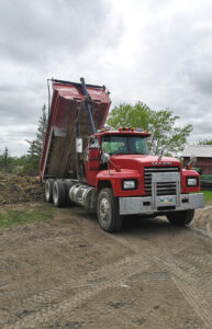 Image of a dump truck dumping dirt