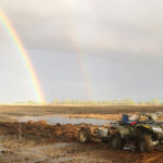 image of a quad on the field and a rainbow in the sky