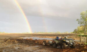 image of a quad on the field and a rainbow in the sky