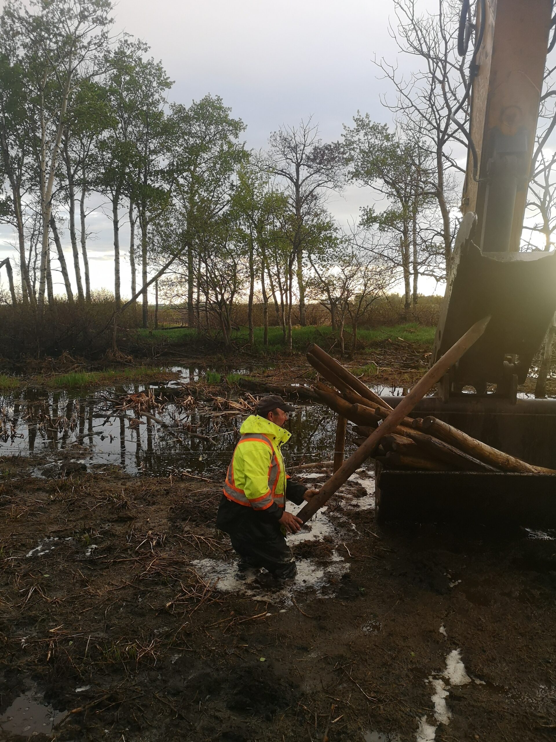 man in a mud pit making a fence