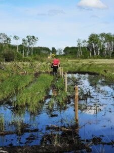man in mud making fence