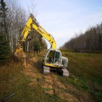 excavator on a hill making a fence