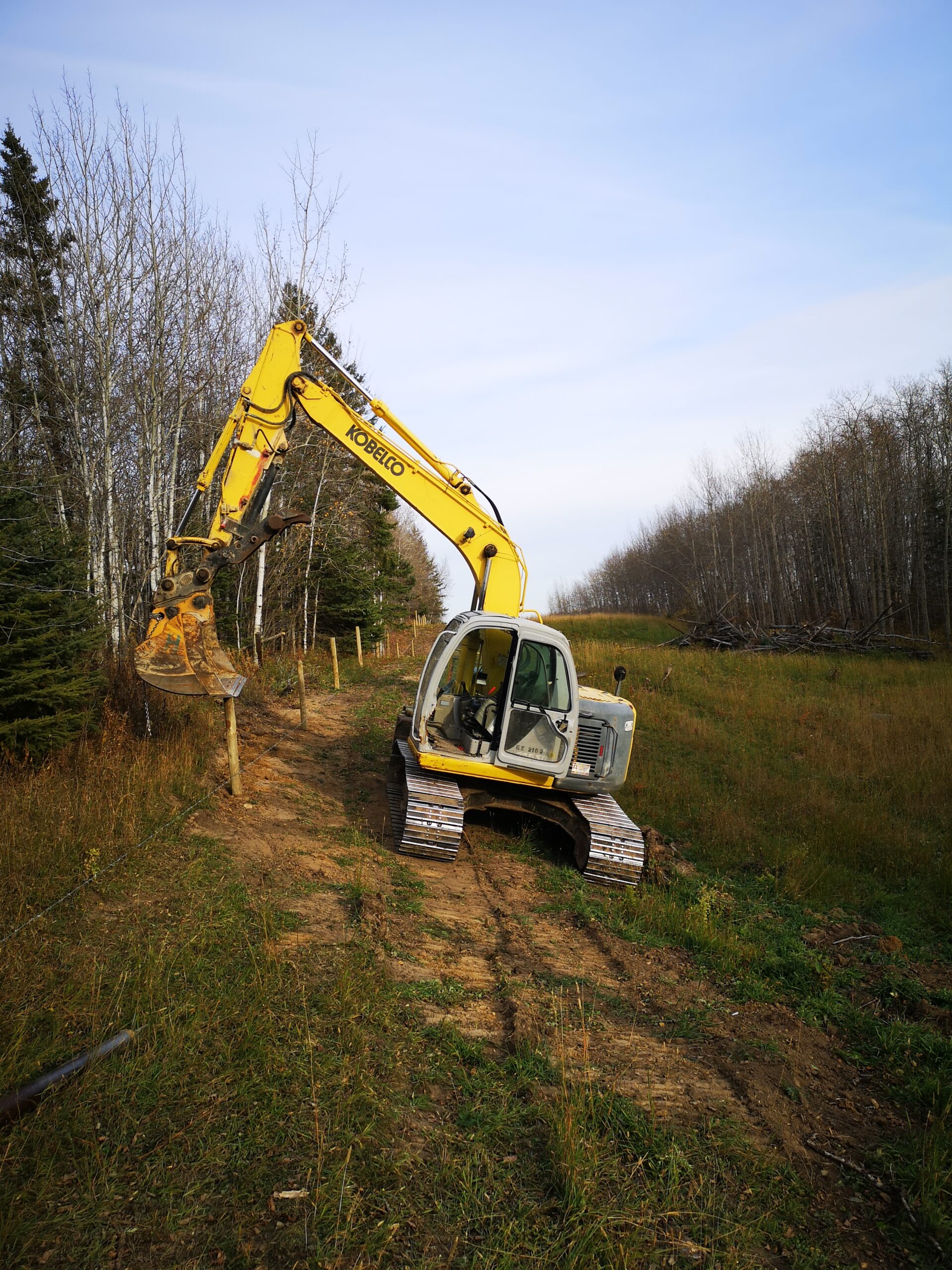 excavator on a hill making a fence